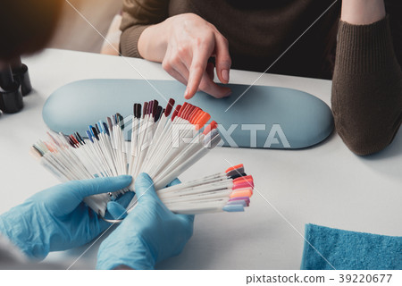 Woman hand choosing color for manicure Woman hand choosing color for manicure 39220677