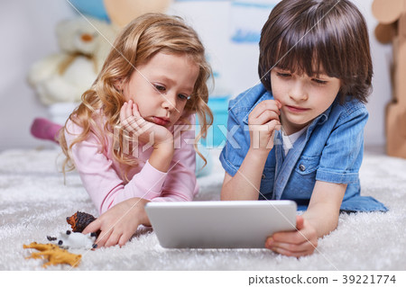 Involved boy and girl watching tablet in children 39221774