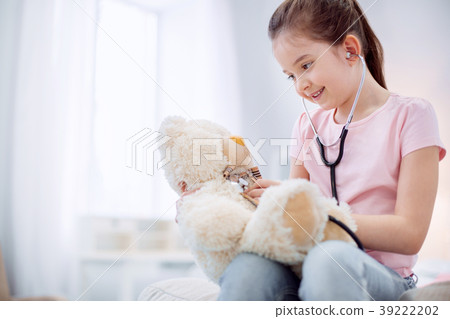 Optimistic energetic girl taking care of plush Optimistic energetic girl taking care of plush 39222202