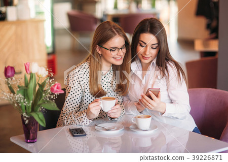 girls sitting in a cafe drinking cappuccino and girls sitting in a cafe drinking cappuccino and 39226871
