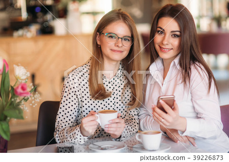 girls sitting in a cafe drinking cappuccino and 39226873