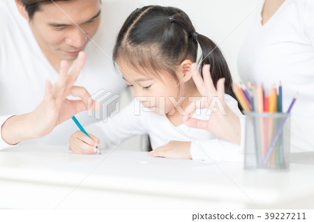Cute girl working on her school project at home. Cute girl working on her school project at home. 39227211