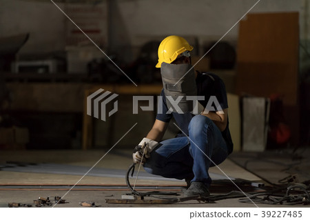 Welder or craftsman in a welding mask in factory. 39227485