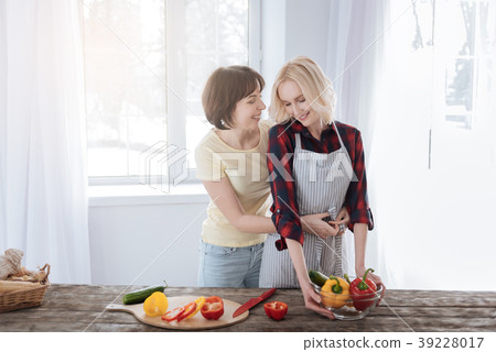Joyful caring woman helping her girlfriend 39228017