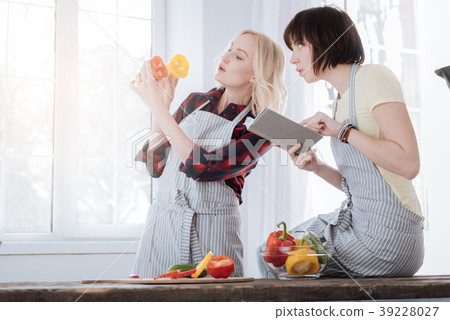 Pleasant young woman reading a recipe Pleasant young woman reading a recipe 39228027