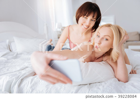 Nice cheerful woman holding her smartphone Nice cheerful woman holding her smartphone 39228084