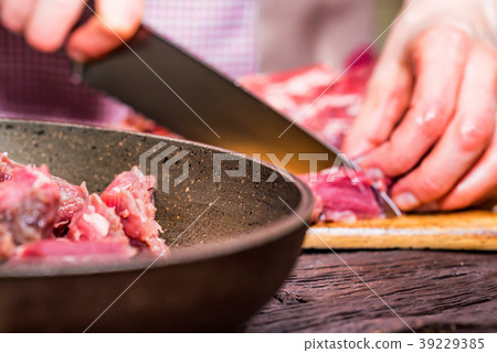 Female hands cut raw beef close Female hands cut raw beef close 39229385