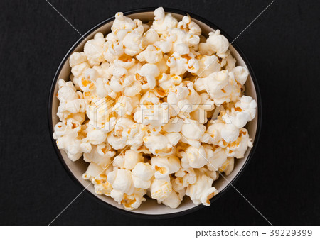 Black bowl with fresh salted popcorn on wood Black bowl with fresh salted popcorn on wood 39229399
