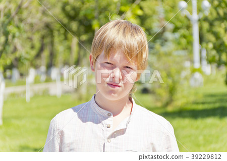 Portrait of serious boy in park Portrait of serious boy in park 39229812