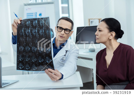 Experienced doctor showing a brain scan 39231919