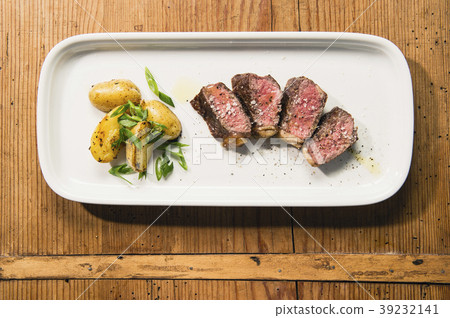 beef and potatoes on white plate with silverware 39232141