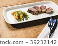 beef and potatoes on white plate with silverware 39232142