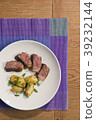 beef and potatoes on white plate with silverware 39232144