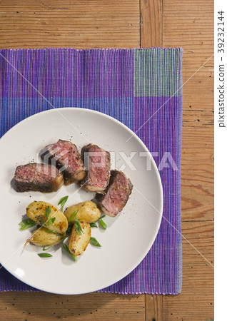 beef and potatoes on white plate with silverware 39232144