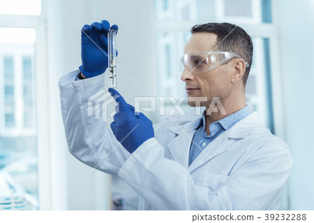 Experienced biologist holding a test tube Experienced biologist holding a test tube 39232288
