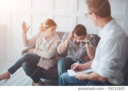 Unhappy bearded man covering his ears 39232885