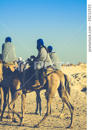 Beduins leading tourists on camels at short Beduins leading tourists on camels at short 39232935