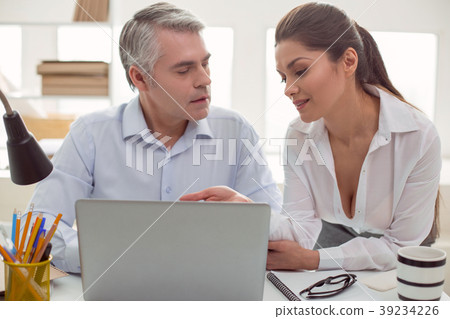 Pleasant young woman sitting with her colleague Pleasant young woman sitting with her colleague 39234226