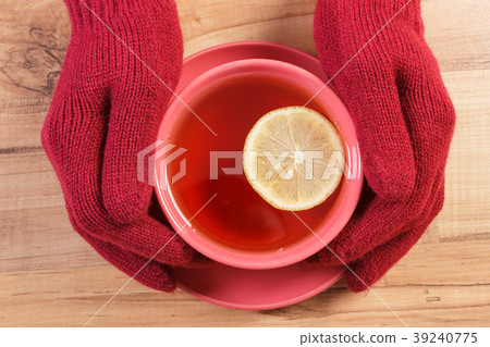 Hand of woman in gloves holding cup of hot tea 39240775