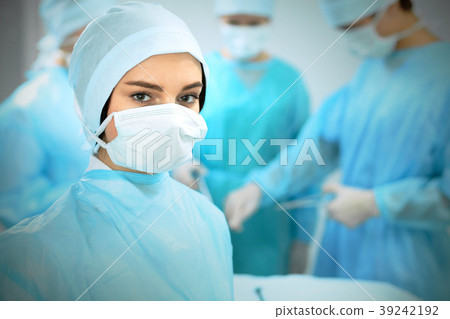 Medical team in masks performing operation. Focus Medical team in masks performing operation. Focus 39242192