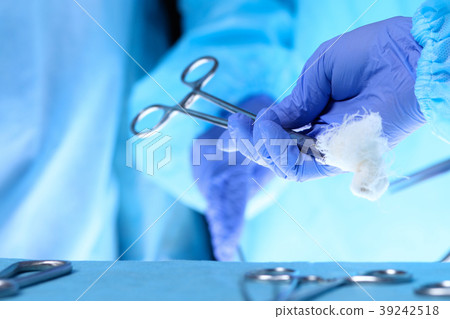 Surgeons hands holding surgical scissors and Surgeons hands holding surgical scissors and 39242518