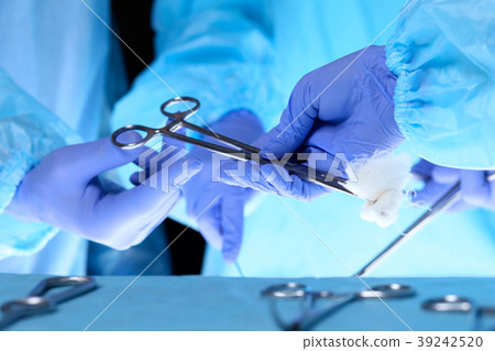 Surgeons hands holding surgical scissors and Surgeons hands holding surgical scissors and 39242520