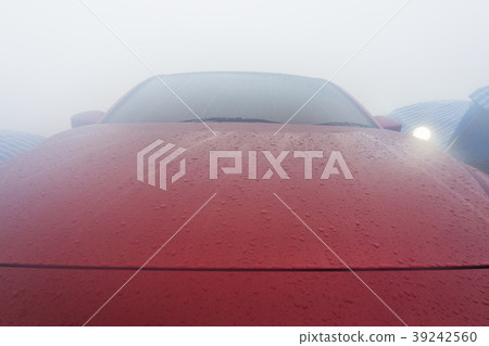 Dew drops on the red car after morning. Dew drops on the red car after morning. 39242560