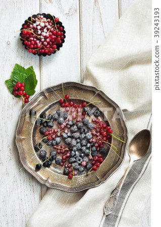 Fresh red and black currant in platter on board. Fresh red and black currant in platter on board. 39243193