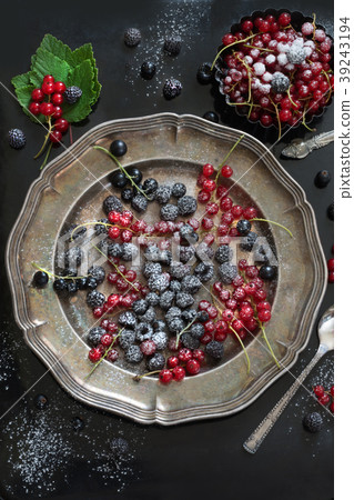 Fresh red and black currant in platter on black. Fresh red and black currant in platter on black. 39243194