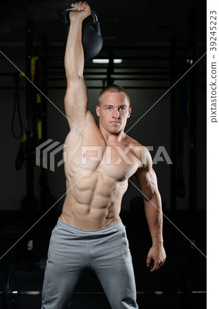 Handsome young man working out in gym kettlebell.. 39245223