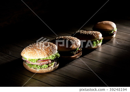 Fresh, tasty burgers in a row. Burgers placed on a Fresh, tasty burgers in a row. Burgers placed on a 39248194