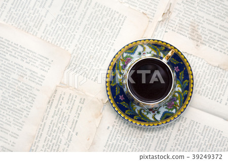 Vintage cup of coffee on old paper sheets or book 39249372