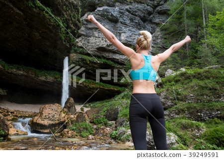 Active woman raising arms inhaling fresh air Active woman raising arms inhaling fresh air 39249591