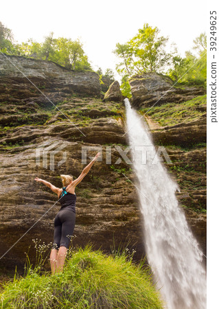 Active woman raising arms inhaling fresh air 39249625
