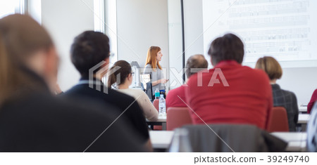 Woman giving presentation in lecture hall at Woman giving presentation in lecture hall at 39249740