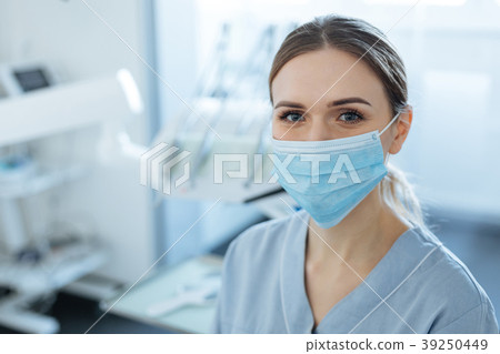 Charming female dentist posing in a face mask Charming female dentist posing in a face mask 39250449