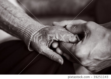 young man holding the hand of an old woman young man holding the hand of an old woman 39251143