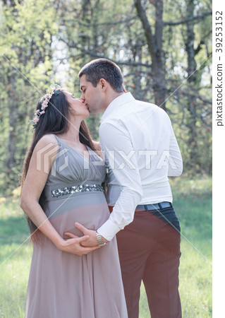 Pregnant couple kissing 39253152