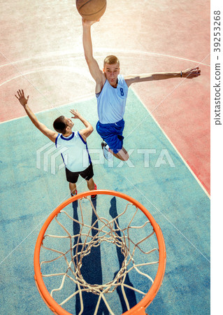 High angle view of basketball player dunking High angle view of basketball player dunking 39253268