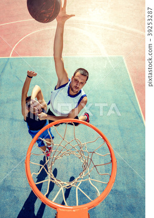 High angle view of basketball player dunking High angle view of basketball player dunking 39253287