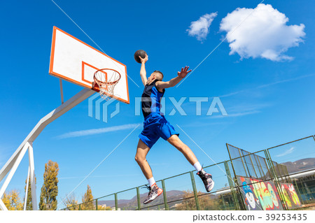 Young Basketball street player making slam dunk Young Basketball street player making slam dunk 39253435