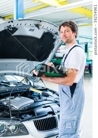 Mechanic with diagnostic tool in car workshop 39254961
