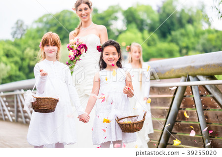 Bride in wedding dress with bridesmaids on bridge 39255020