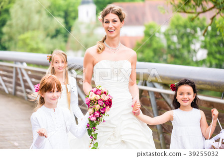 Bride in wedding dress with bridesmaids on bridge 39255032