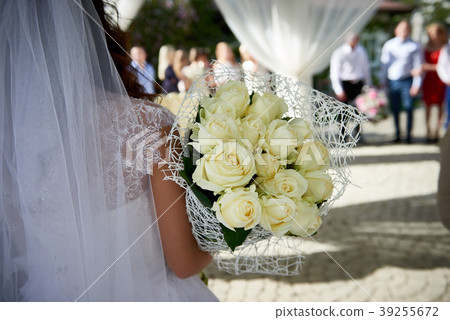 Back view of bride with white roses outdoors Back view of bride with white roses outdoors 39255672