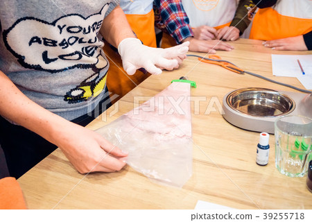 Hands hold confectionery bag swith macaron batter Hands hold confectionery bag swith macaron batter 39255718