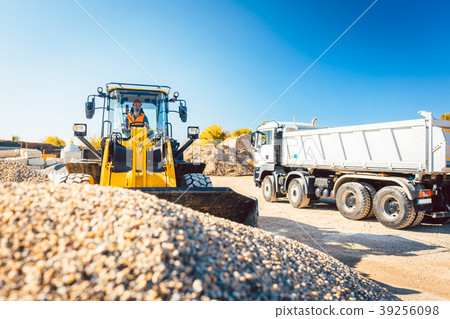 Construction workers doing earthworks with wheel Construction workers doing earthworks with wheel 39256098