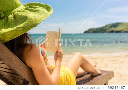 Young beautiful woman reading a book at the beach 39256467