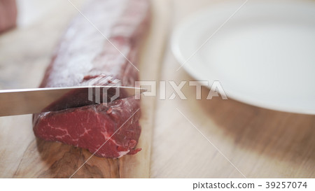 female hands slicing raw beef fillet for steak on female hands slicing raw beef fillet for steak on 39257074