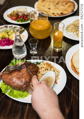 Man eats tasty dish of pork shank 39257558